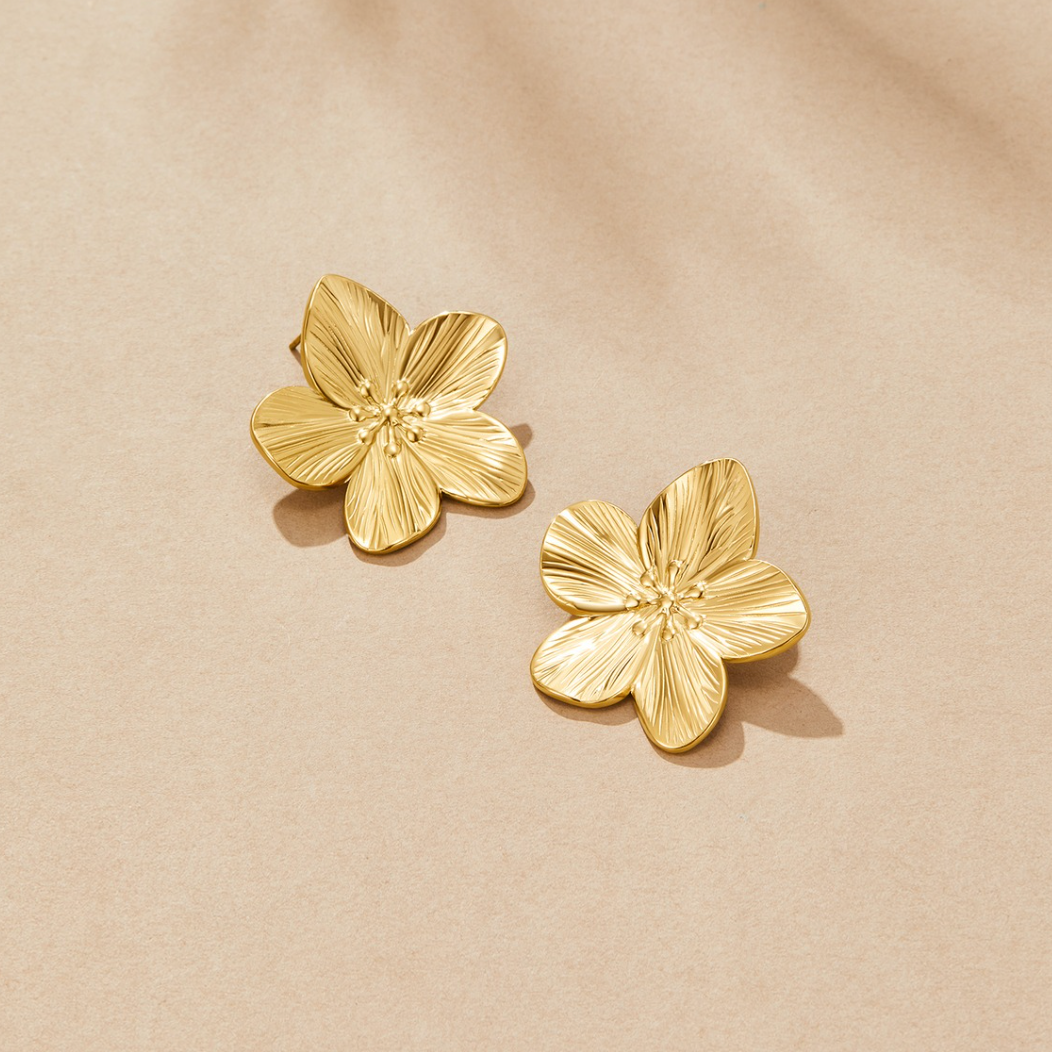 Brincos dourados com design floral