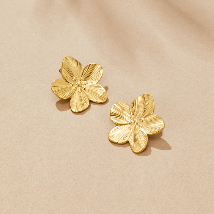 Brincos dourados com design floral
