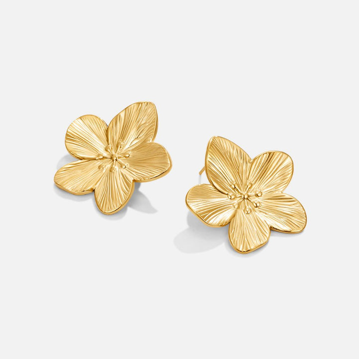 Brincos dourados com design floral